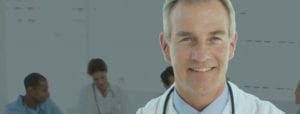 doctor smiling with other doctors in background