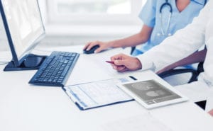 doctors at desk with medical image viewer